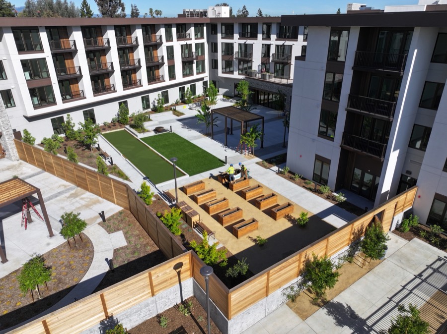 Aerial view of a multi-family courtyard with wood fencing, planters and seating