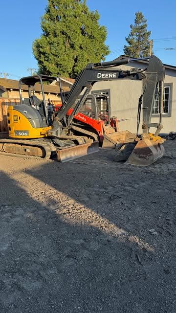 Excavator and skid steer grading a residential lot